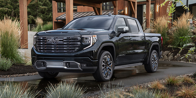 2026 GMC Sierra 1500 parked outdoors showcasing its bold front grille, rugged stance, and premium exterior design.