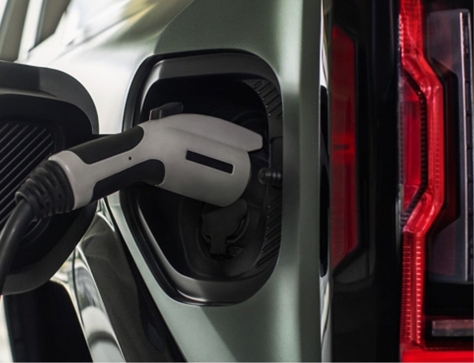 Close up of charging port with charger plugged in on a GMC Hummer EV SUV - Royal GMC in COLDWATER MI