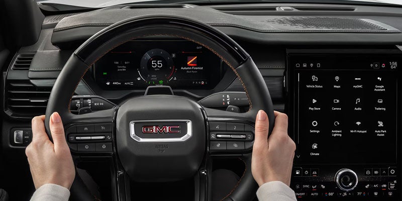 2026 GMC Acadia driver cockpit with steering wheel and infotainment display